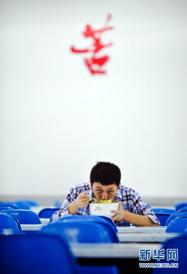 A Changsha, capitale de la province du Hunan, un lycéen prend son déjeuner dans la salle de classe le 24 mai 2012. Il a décidé de rester au lycée pour une année de plus afin de pouvoir être admis par une meilleure université. Bien que le Gaokao (concours national d'entrée à l'université) ne soit pas la seule façon de réussir en Chine, la plupart des jeunes Chinois espèrent changer leur destin grâce à cette précieuse opportunité.