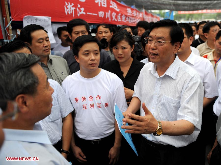 Photo d'archive prise le 29 juin 2008 montrant Zhang Dejiang (à droite au premier plan) parlant avec des gens dans un salon de l'emploi lors de son inspection sur les efforts d'assistance-emploi pour Dujiangyan, la ville durement touchée par un séisme, dans la province du Sichuan (sud-ouest), en Chine.