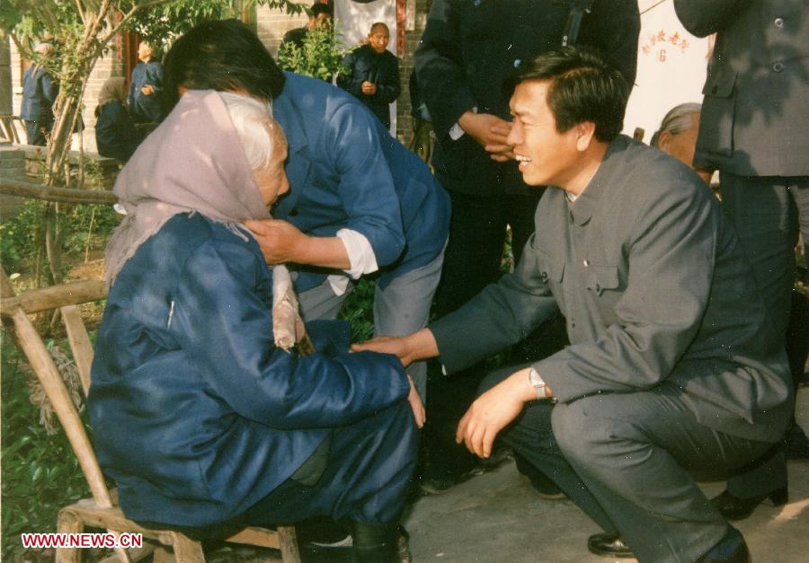 Photo d'archive montrant Zhang Dejiang (à droite), alors qu'il travaillait au ministère des Affaires civiles, rendant visite à une femme centenaire lors de son enquête sur les maisons rurales de soins infirmiers dans la province centrale du Henan, en Chine.