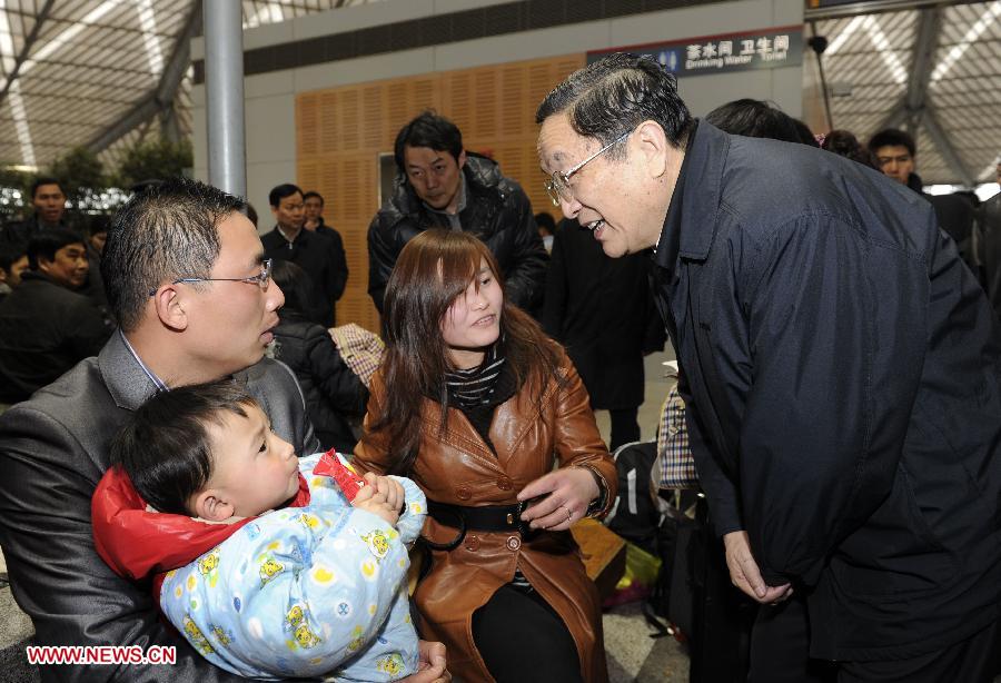 Photo d'archive prise le 11 février 2010 montrant Yu Zhengsheng (à droite) parlant avec des passagers lors de son inspection de la Gare du Sud de Shanghai, au moment du pic des voyages de la fête du printemps, dans la municipalité de Shanghai (est).