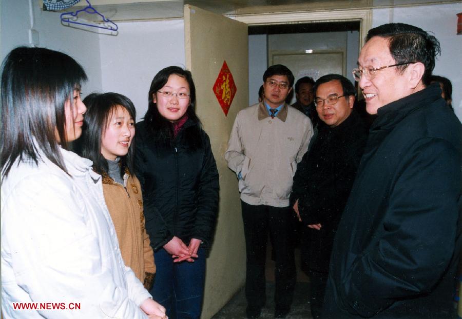 Photo d'archive prise le 16 mai 2005 montrant Yu Zhengsheng (à droite) parlant avec des étudiantes universitaires dans leur dortoir à l'Université de Wuhan, dans la capitale de la province du Hubei (centre).