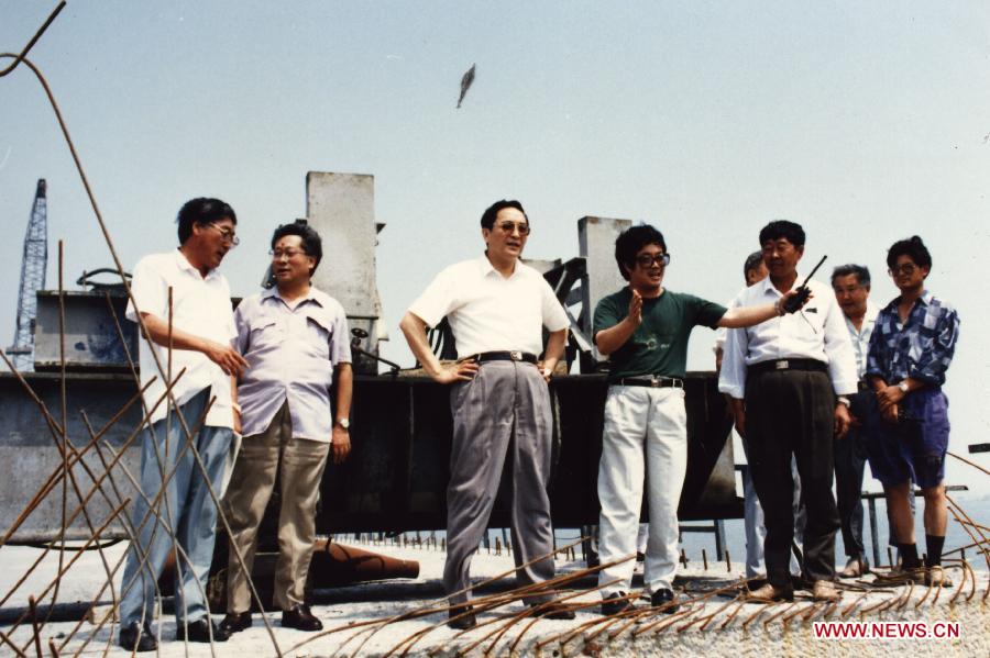 Photo d'archive prise en 1994 montrant Yu Zhengsheng (troisième à gauche) lors de son inspection sur un chantier de construction d'une autoroute enjambant la mer à Qingdao, ville côtière de la province orientale du Shandong.