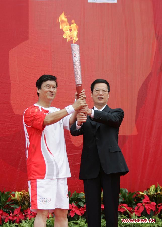 Photo d'archive prise le 1er août 2008 montrant Zhang Gaoli (à droite) remettant la torche olympique au travailleur national modèle Kong Xiangrui dans la municipalité de Tianjin. (Photo : Song Ziming)
