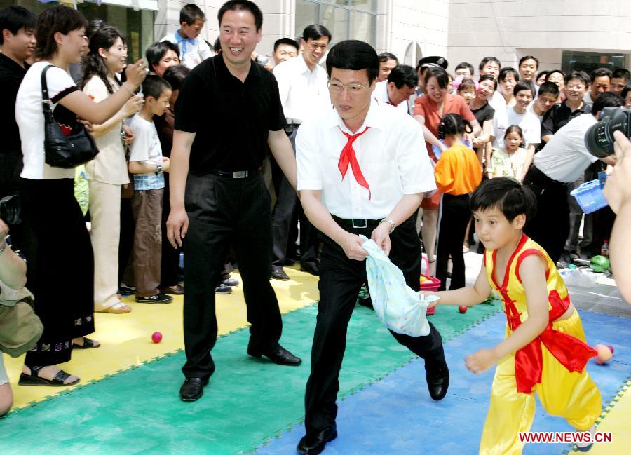 Photo d'archive prise le 1er juin 2005 montrant Zhang Gaoli (au centre) rendant visite à des enfants dans un centre d'animation pour les femmes et les enfants à Jinan, capitale de la province du Shandong (est). (Photo : Xinhua)