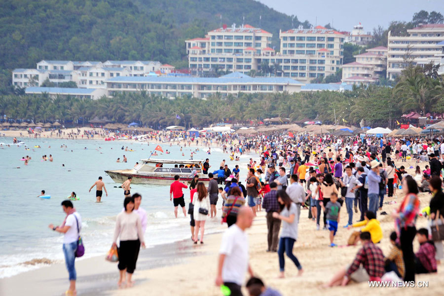 Des gens s'amusent au bord de la mer à Sanya, dans la province de Hainan (sud), le 31 décembre 2012. De nombreux touristes se sont rendus à Sanya pour passer le dernier jour de l'année.