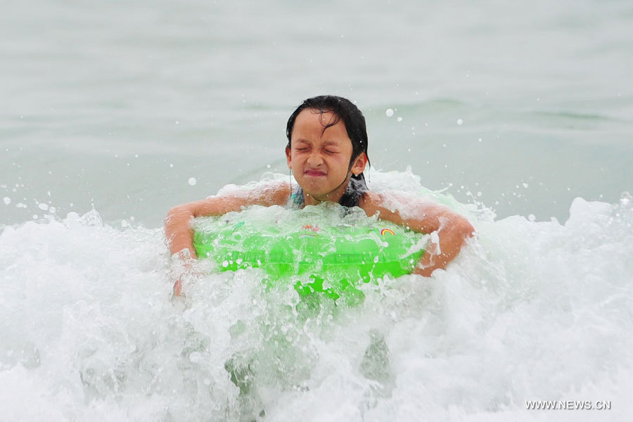 Une fillette s'amuse dans la mer à Sanya, dans la province de Hainan (sud), le 31 décembre 2012. De nombreux touristes se sont rendus à Sanya pour passer le dernier jour de l'année.