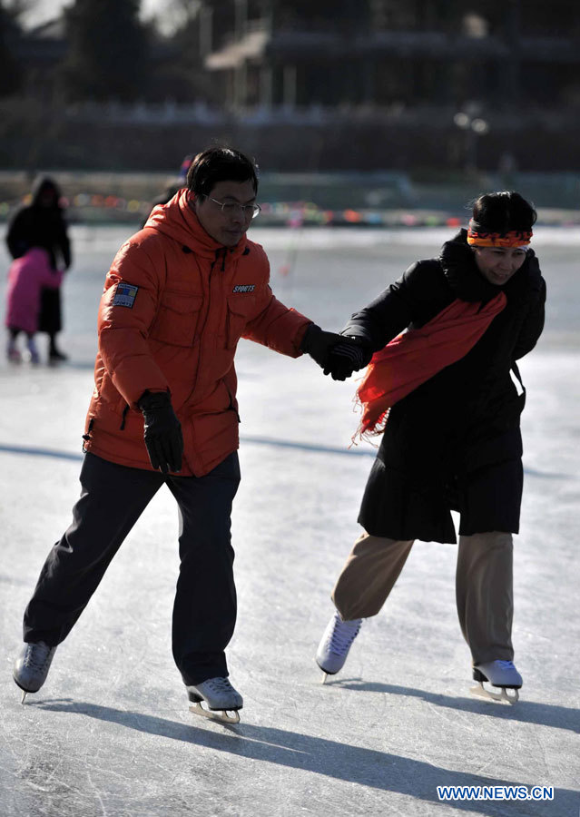 Des citoyens s'amusent à faire du patinage sur le lac gelé au Parc Taoranting, le 3 janvier 2013 à Beijing. (Photo : Li Wen)