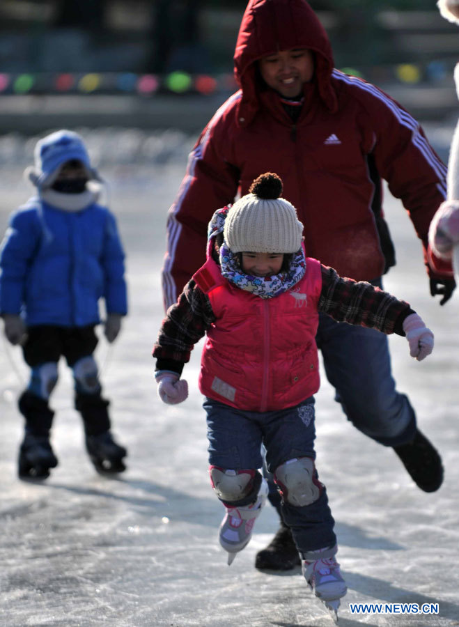 Des enfants s'amusent à faire du patinage sur le lac gelé au Parc Taoranting, le 3 janvier 2013 à Beijing. (Photo : Li Wen)