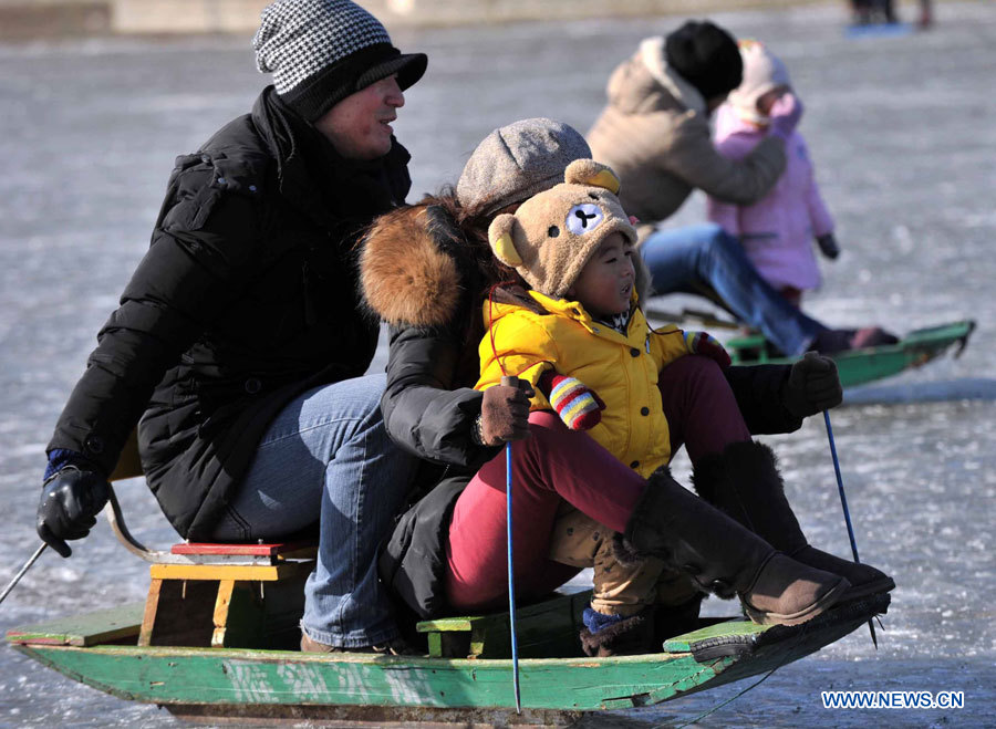Des citoyens s'amusent à faire des glissades sur le lac gelé au Parc Taoranting, le 3 janvier 2013 à Beijing. (Photo : Li Wen)