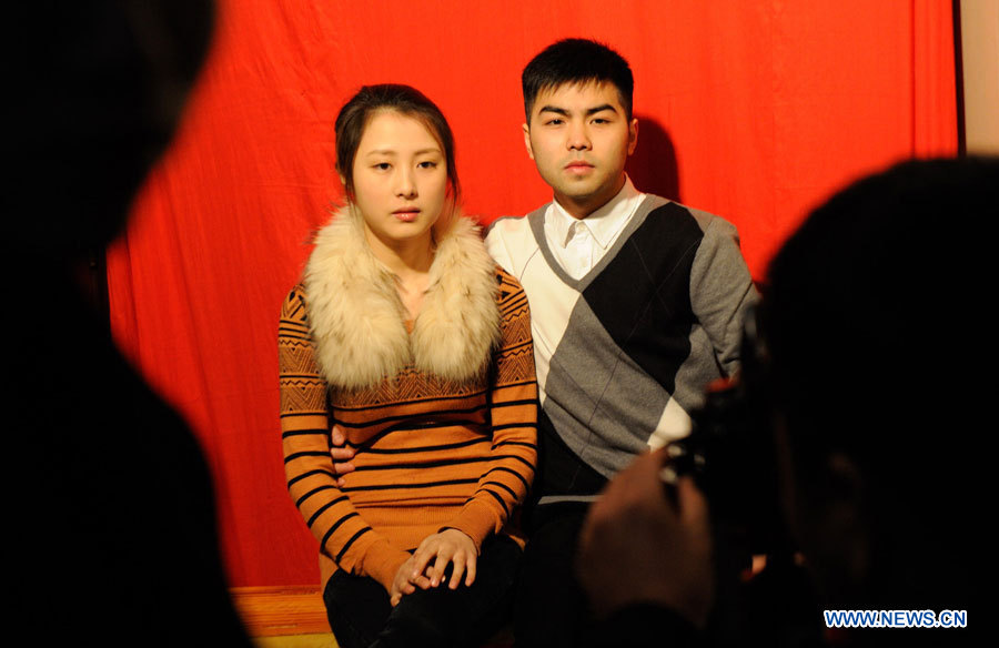 Un couple pose pour une photo dans le bureau d'enregistrement des mariages de l'arrondissement de Jiangbei, dans la ville de Chongqing (sud-ouest), le 4 janvier 2013. De nombreux couples ont enregistré leur mariage le 4 janvier 2013, dont la prononciation en chinois ressemble à "je t'aimerai à jamais". (Photo : Li Jian)