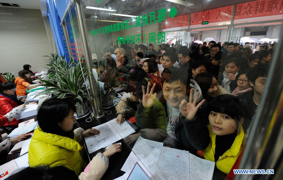 Des couples se ruent dans le bureau d'enregistrement des mariages de l'arrondissement de Jiangbei, dans la ville de Chongqing (sud-ouest), le 4 janvier 2013. De nombreux couples ont enregistré leur mariage le 4 janvier 2013, dont la prononciation en chinois ressemble à "je t'aimerai à jamais". (Photo / Li Jian)