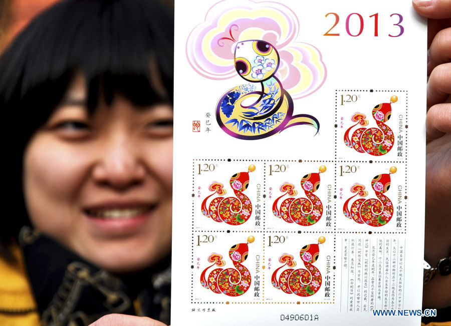 Une employée de la poste de Binzhou, ville de la province du Shandong, montre le timbre de l'année du serpent (2013), le 4 janvier 2013. Ce nouveau timbre sera émis par China Post à partir du 5 janvier. 