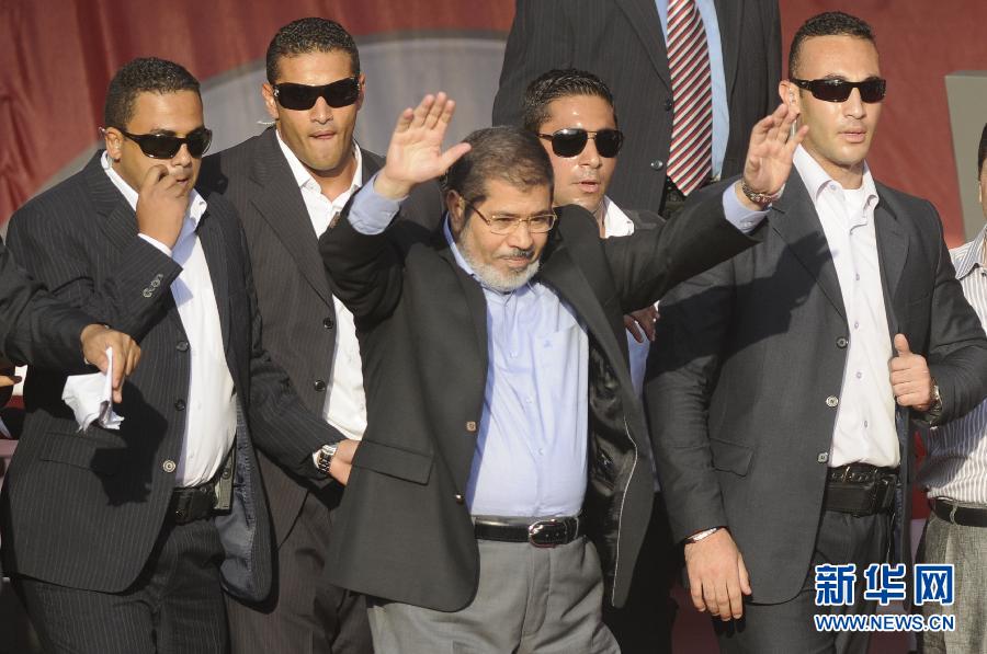 Le 29 juin 2012, le président de l'Egypte Mohamed Morsy (au milieu) salue de la main ses supporteurs sur la Place Tahrir au Caire en Egypte. (Xinhua/AFP)