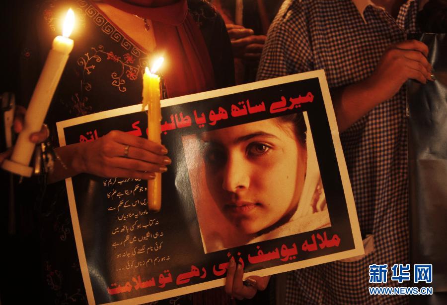 Une pakistanaise tient une bougie et une pancarte sur laquelle nous pouvons lire « Vous restez avec nous ou à côté des Talibans ? Vive Malala Yousafzai », lors d'une veillée à Islamadad le 11 octobre 2012. (Xinhua/AP)