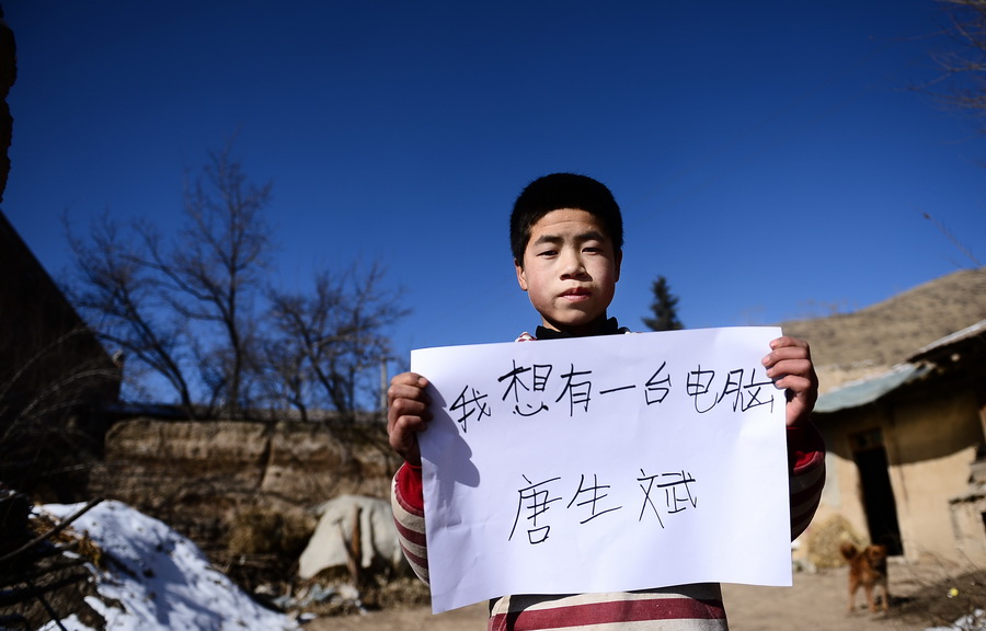 « Je veux un ordinateur ». C'est le souhait de Tang Shengbin, élève en 6e année de l'école primaire. Comme leur père travaille à la ville et ne rentre pas souvent, même pendant la Fête du Printemps, ce petit garçon et son petit frère Tang Shenghui restent avec leurs grands-parents. Agé de 13 ans, il sait déjà s'occuper de son petit frère : « Mes grands-parents sont tous âgés, ainsi il me faut les aider à prendre soin de mon frère. » (Xinhua/Zhang Hongxiang)