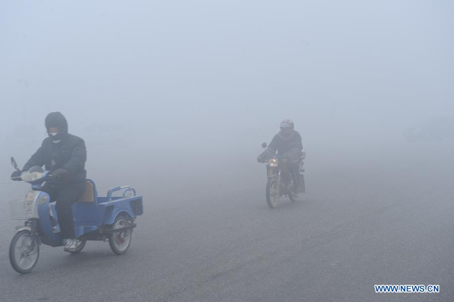 Des véhicules roulent sur une route recouverte de brouillard, à Baoding, ville de la province du Hebei (nord), le 12 janvier 2013.