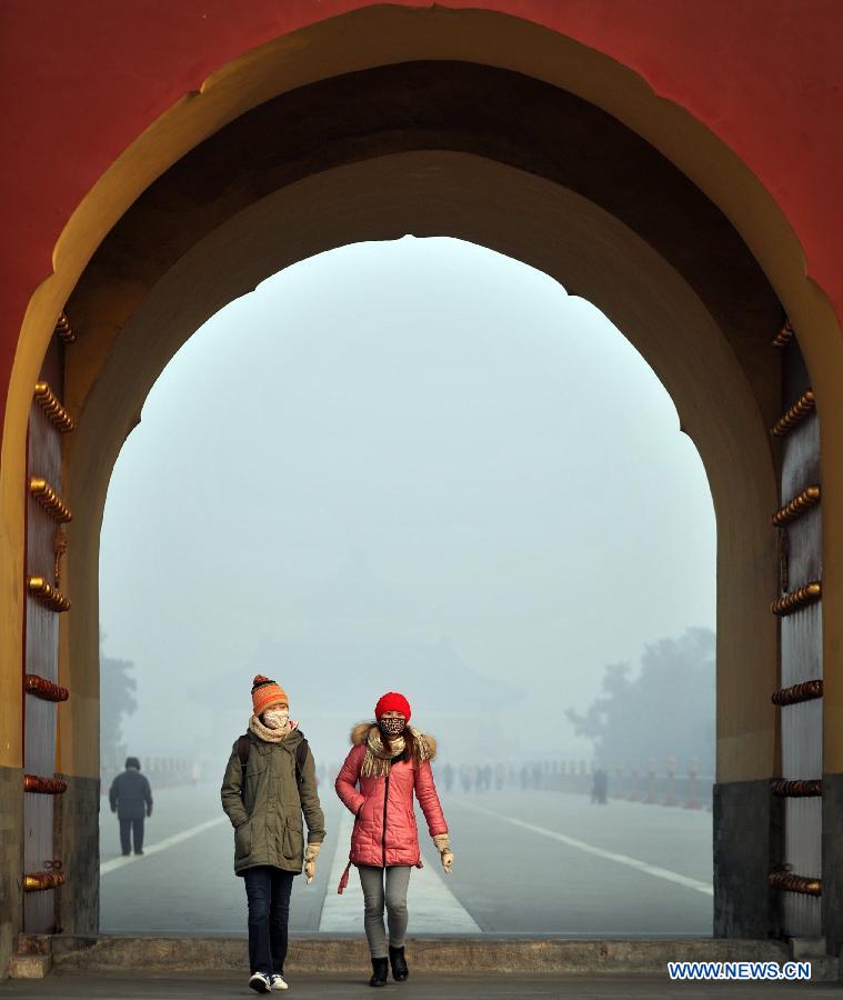 Deux visiteurs portant des masques au Temple du Ciel enveloppé par le brouillard à Beijing, capitale de la Chine, le 12 janvier 2013. Un épais brouillard a frappé samedi la ville de Beijing. (Xinhua / Li Wen)