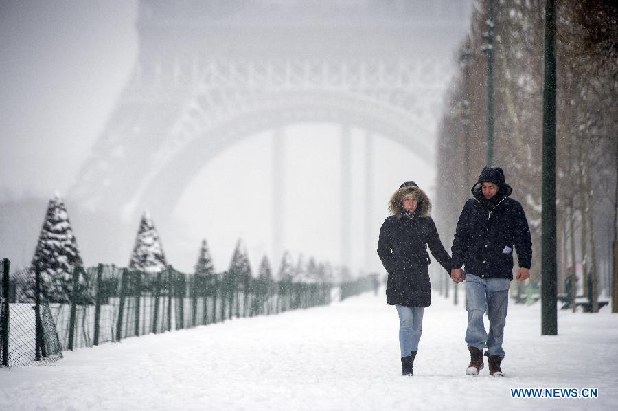 Photo prise le 20 janvier montrant des gens qui marchent sur les routes recouvertes de neige à Paris.  