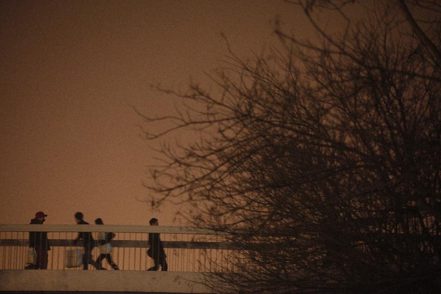 Des piétons aperçus dans le brouillard à Beijing, capitale de la Chine, le 22 janvier 2013. L’observatoire météorologique de Beijing a émis une alerte jaune au brouillard épais mardi. (Xinhua / Wang Shen)