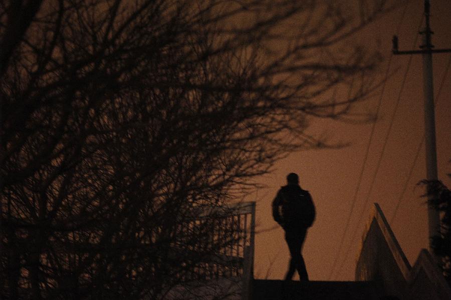 Un piéton sur une passerelle se détache dans le brouillard à Beijing, capitale de la Chine, le 22 janvier 2013. L’observatoire météorologique de Beijing a émis une alerte jaune au brouillard épais mardi. (Xinhua / Wang Shen)