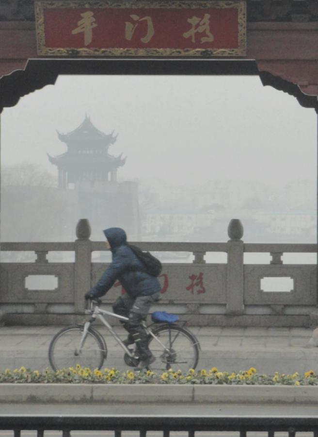 Un homme à vélo sur un pont enveloppé par le brouillard dans la ville de Suzhou, dans la province du Jiangsu, dans l'Est de la Chine, le 22 janvier 2013. (Xinhua / Wang Jiankang)