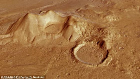 Une chaîne de montagnes qui s'élève sur les hautes terres de Promethei Terra et un cratère gigantesque à côté d'elle.  