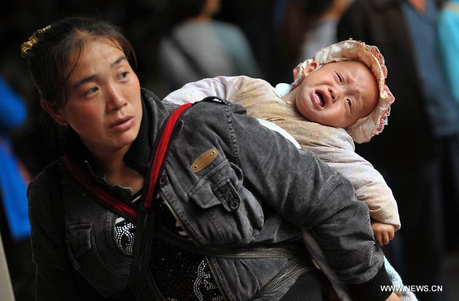 Le 24 janvier 2013, dans le port de Xiuying à Haikou, la capitale de la province chinoise de Hainan Une femme portant un bébé au dos est prête à embarquer.  A l'approche de la Fête du Printemps, la ville a connu ces derniers jours des pics de fréquentation dans les transports. (Xinhua/Guo Cheng)