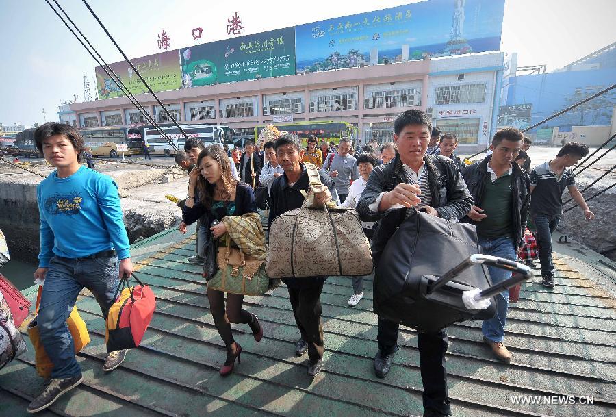Le 24 janvier 2013, dans le port de Xiuying à Haikou, la capitale de la province chinoise de Hainan, de nombreux passagers prêts à s'embarquer sur un bateau pour rentrer chez eux. Ces derniers jours, à l'approche de la Fête du Printemps, la ville a connu ces derniers jours des pics de fréquentation dans les transports. (Xinhua/Guo Cheng)