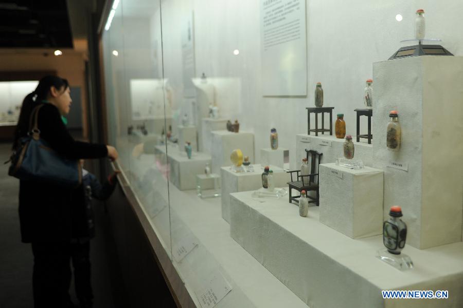 Une visiteuse devant les objets artistiques présentés lors d'une expostition de la culture traditionnelle chinoise ouverte à Shijiazhuang le 28 janvier 2013. (Xinhua/Zhu Xudong)