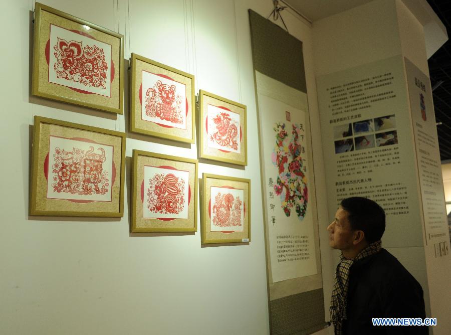 Un visiteur contemple les oeuvres du découpage de papier présentés lors d'une expostition de la culture traditionnelle chinoise ouverte à Shijiazhuang le 28 janvier 2013. (Xinhua/Zhu Xudong)