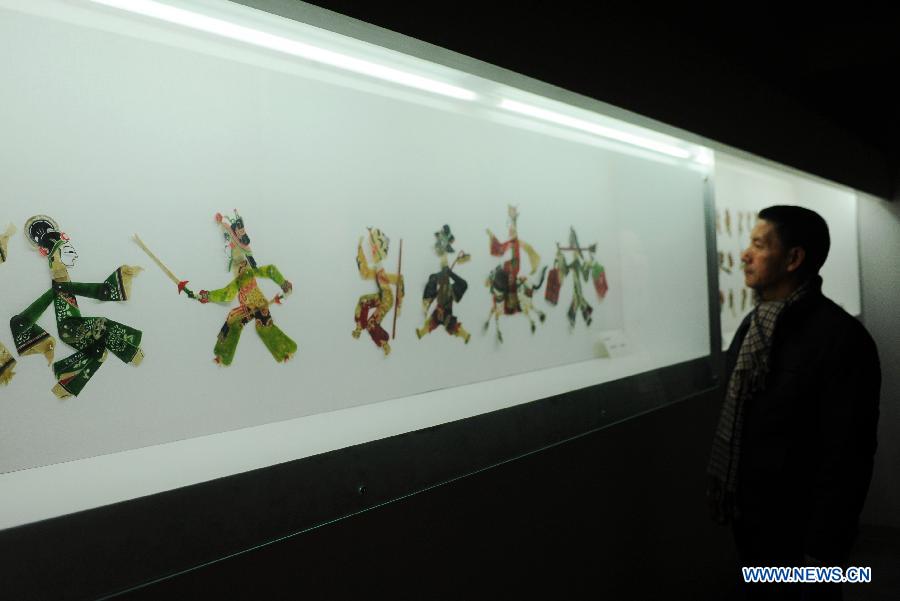 Un visiteur admire les personnages du théâtre d'ombres de Tangshan, lors de l'Exposition de la culture traditionnelle chinoise ouverte à Shijiazhuang le 28 janvier 2013. (Xinhua/Zhu Xudong)