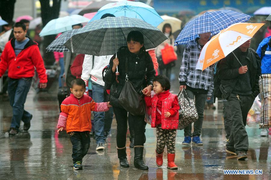Une mère se déplace avec ses deux enfants, le 26 janvier 2013, sur la place de la gare de Nanning, la capitale de la Région autonome Zhuang du Guangxi du sud de la Chine. (Xinhua/Huang Xiaobang)