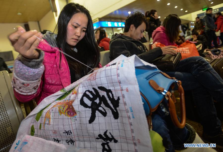 En attendant son train à la gare de Hangzhou, Gong Pinghui, une jeune femme âgée de 25 ans et venant de la province du Shaanxi, s'adonne à la broderie. (Xinhua/Han Chuanhao)