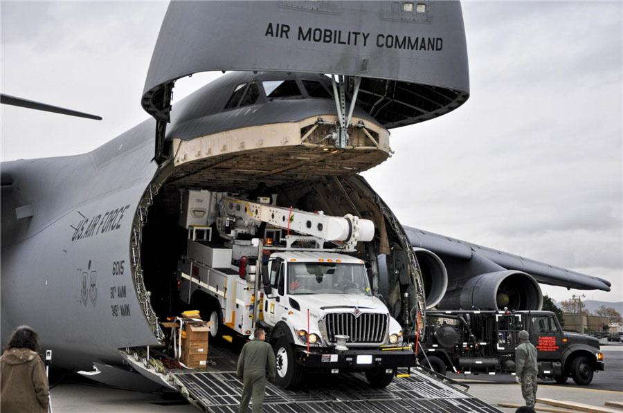 Des manutentionnaires et des gardes de l'air déchargent un véhicule de soutien d'un Galaxy C-5 à Newburgh, New York, le 1er novembre 2012.