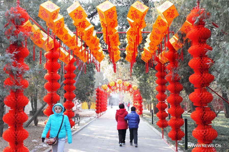 Des touristes découvrent une galerie décorée de lanternes rouges au parc du Temple de la Terre à Beijing, le 2 février 2013. (Xinhua)
