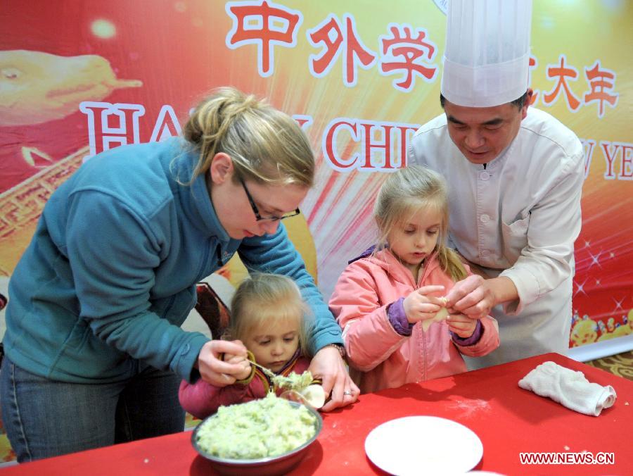 Une étudiante étrangère et ses deux filles apprennent à préparer des raviolis chinois lors des activités organisées pour fêter le Nouvel An chinois à l'Université d'Agriculture de Nanjing, capitale de la province du Jiangsu en Chine. (Xinhua)