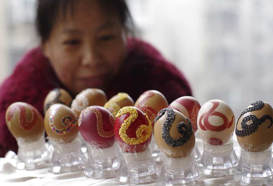 Wang Qiuyi admire les œufs qu'elle a décorés pour la nouvelle année du Serpent à Pingdingshan, dans la province du Henan, le 29 janvier 2013.
