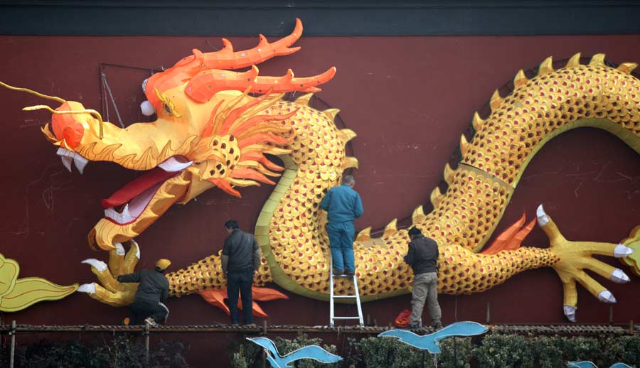 Des ouvriers installent des lanternes de la forme de dragons sur les enceintes du temple de Confucius à Nanjing, dans la province du Jiangsu (est), le 26 janvier 2012.