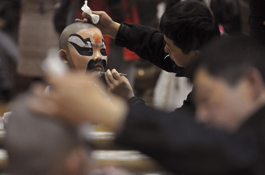 Des acteurs professionnels de l'opéra de Pékin aident des élèves de l'école primaire à se maquiller, durant les préparations en coulisses avant de monter sur scène pour leur spectacle du Nouvel An chinois à Nanjing, dans la province du Jiangsu. Photo prise le 27 janvier 2013.
