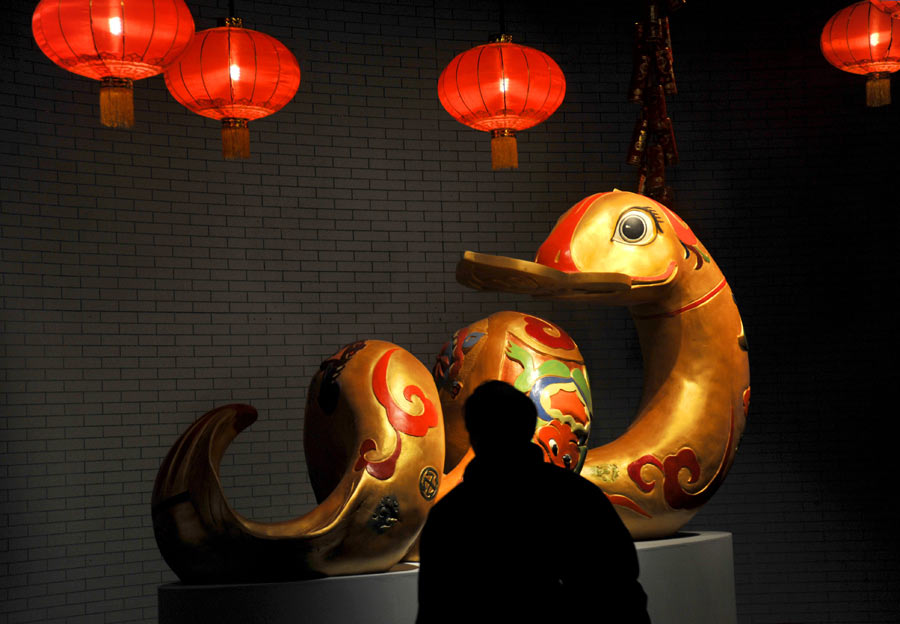 Un homme admire une statue de serpent à Beijing, le 5 février 2013.