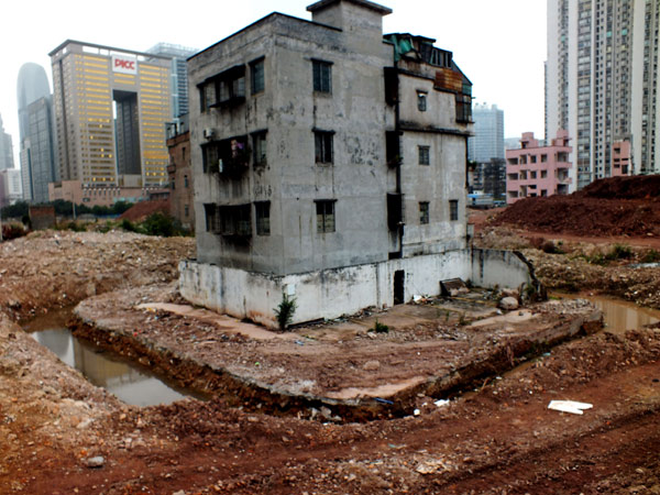 Un bâtiment isolé par des tranchées, sur un chantier de construction dans le village de Yangqi, dans la ville de Guangzhou, capitale de la Province du Guangdong, dans le sud de la Chine, le 6 février 2013.