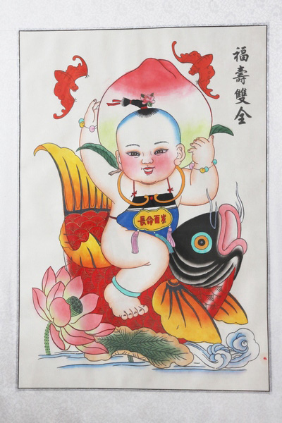 Les Nianhua, les peintures du Nouvel An lunaire, de l'atelier Yongshunhao du comté de Huaxian, contenant des images d'un poisson, d’un garçon, de deux chauves-souris, une pêche et une fleur de lotus. La peinture reflète la volonté du peuple de pouvoir jouir du bonheur, de la richesse et la longévité de la vie. Photos : Bi xingshi/China Daily