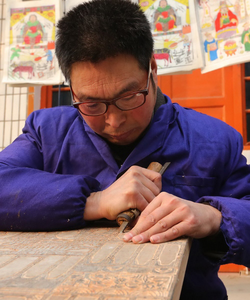 Le 8 janvier, Geng Jianshe, de le 27e génération des artisans des Huaxian Nianhua, les peintures du Nouvel An, sculpte un bloc de bois, dans l'atelier Yongshunhao dans le village de Malan du comté de Huaxian, dans la province du Henan.