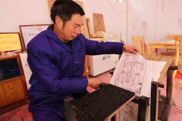 Le 8 janvier, Geng Jianshe, de la 27e génération des artisans des Huaxian Nianhua, les peintures du Nouvel An, sculpte un bloc de bois,dans l'atelier Yongshunhao dans le village de Malan du comté de Huaxian, dans la province du Henan.