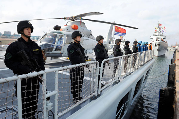 Des membres des forces spéciales de la marine chinoise sur le pont de la frégate lance-missiles « Mianyang », attendant leur départ pour le Golfe d'Aden et les eaux au large de la Somalie pour une mission d'escorte, dans un port de Qingdao, dans la Province du Shandong, dans l'Est de la Chine le 16 février 2013. La flottille, la 14e de son genre à être engagée dans des missions d'escorte, se compose d'un destroyer lance-missiles, une frégate et un navire de ravitaillement qui appartiennent tous à la Flotte de la Mer du Nord de la Marine de l’Armée Populaire de Libération (APL).