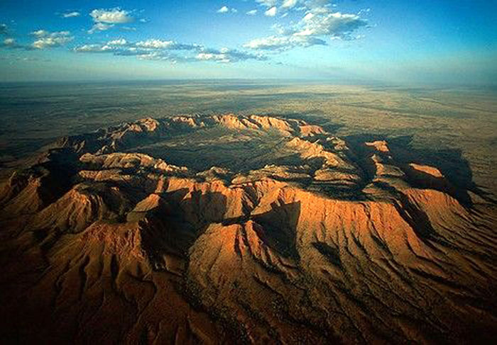 Le cratère de Gosses Bluff, situé dans le Territoire du Nord en plein cœur de l'Australie, fut créé il y a 142 millions d'années par l'impact d'une comète ou d'un astéroïde sur la Terre à la vitesse de 40 km/s. L'énergie produite est égale à celle dégagée par l'explosion de 22 000 mégatonnes de TNT. Cet impact a formé ce cratère d'un diamètre de 24 km.