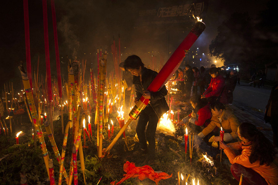 Plus de 10 000 personnes ont afflué vers le parvis d'un temple bouddhiste pour y brûler des bâtons d'encens, dans la municipalité de Chongqing, en Chine du Sud-Ouest, dans la nuit du réveillon du Nouvel An chinois, le 9 février 2013. [Photo Yu Xiao / China Daily]
