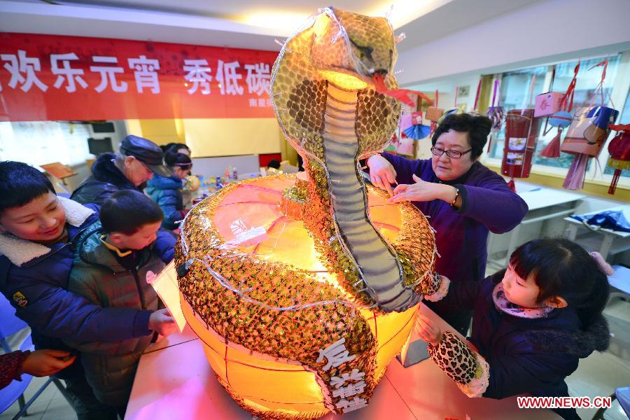 Des habitants confectionnent une lanterne à partir de matériaux usagés dans une communauté de Hangzhou, capitale de la Province du Zhejiang, dans  l'Est de la Chine, le 18 février 2013. La Fête traditionnelle des Lanternes tombe cette année le 24 février 2013. (Li Zhong / Xinhua)