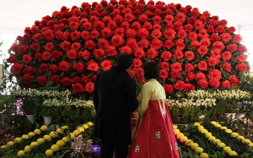 Durant la 17e édition de l'Exposition de Fleurs Kim Jong-il, une guide présente les fleurs nommées d'après les anciens dirigeants nord-coréens Kim Il-sung et Kim Jong-il.