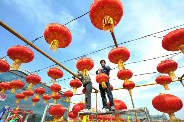 Les employés accrochent des lanternes pour la Fête des Lanternes, qui tombe le 24 février, à Zhongwei, dans la Région Autonome Hui du Ningxia, le 21 février 2013. [Photo / Xinhua]